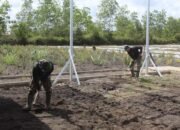 Satgas TMMD Kodim 1012/Buntok Gunakan Cangkul Bersihkan Rumput untuk Ketahanan Pangan